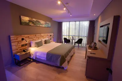 a bedroom with a large bed and a table with chairs at ÑU Posta Urbana Hotel Boutique in Cordoba