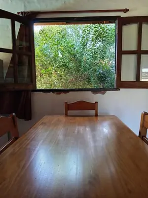 a large wooden table in a room with a window at Cabaña Las liebres in San Roque