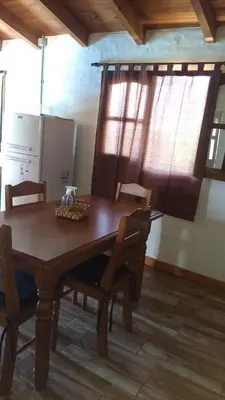 a dining room table and chairs in a kitchen at Cabaña Las liebres in San Roque