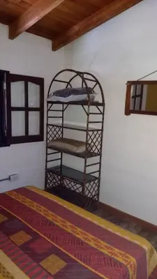 a room with a bed and a shelf in a room at Cabaña Las liebres in San Roque