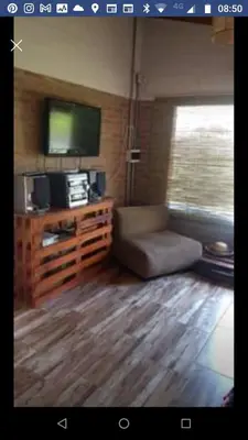 a living room with a couch and a flat screen tv at Cabaña Las liebres in San Roque