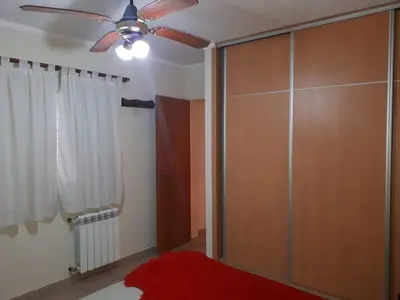 a living room with a ceiling fan and a closet at DEPARTAMENTO CARLOS PAZ in Villa Carlos Paz