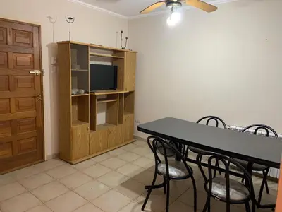 a dining room with a table and chairs and a television at DEPARTAMENTO CARLOS PAZ in Villa Carlos Paz