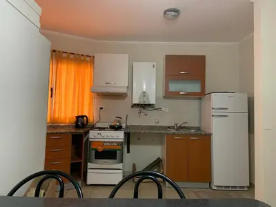 a kitchen with a white refrigerator and a stove at DEPARTAMENTO CARLOS PAZ in Villa Carlos Paz