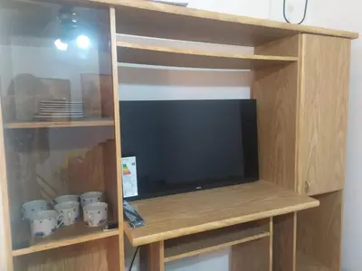 a tv in a wooden book shelf with a tv at DEPARTAMENTO CARLOS PAZ in Villa Carlos Paz