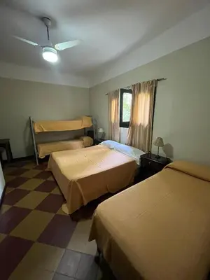 a hotel room with two beds and a checkered floor at Posada del Bosque in Tanti
