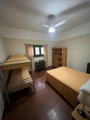 a bedroom with two bunk beds and a table at Posada del Bosque in Tanti