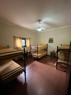 a room with several bunk beds in a building at Posada del Bosque in Tanti