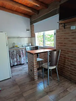 a kitchen with a table and chairs in a room at MONOAMBIENTES LOS SAUCES in Mina Clavero