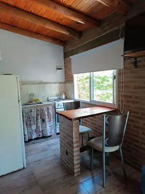 a kitchen with a table and chairs in a room at MONOAMBIENTES LOS SAUCES in Mina Clavero
