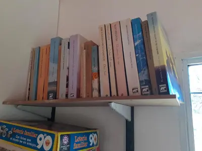 a row of books sitting on a shelf at La Nubia Cabañas in Conlara
