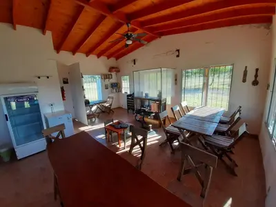 a living room with a wooden table and chairs at La Nubia Cabañas in Conlara