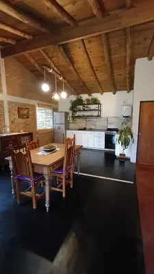 a kitchen and dining room with a table and chairs at Casa LA OCASIÓN in Los Reartes