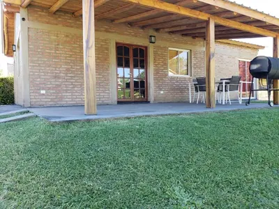a house with a patio with chairs and a grill at Casa LA OCASIÓN in Los Reartes
