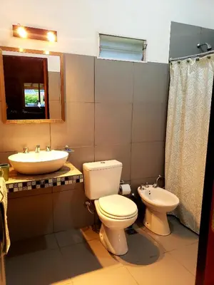 a bathroom with a toilet and a sink at Casa LA OCASIÓN in Los Reartes