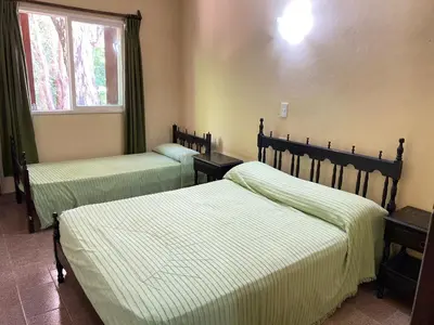 a bedroom with two beds and a window at Departamentos LOS CEDROS in Mina Clavero