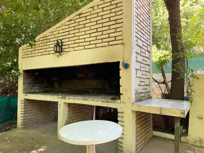 a brick oven with a table and a bench in it at Departamentos LOS CEDROS in Mina Clavero