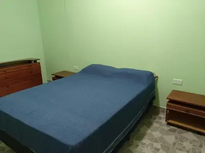 a bedroom with a blue bed and two night stands at Departamentos LOS CEDROS in Mina Clavero