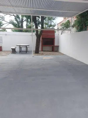 a concrete patio with a table and a tree at Departamentos la Familia NONO in Nono