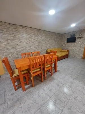 a room with a wooden table and chairs and a couch at Departamentos la Familia NONO in Nono