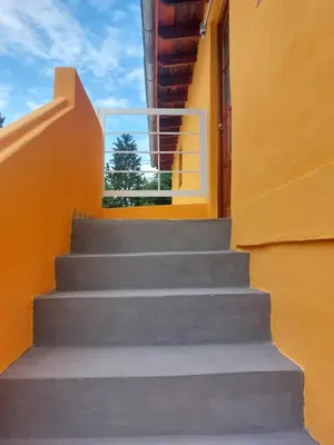 a set of stairs leading up to a yellow building at Departamentos la Familia NONO in Nono