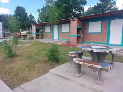 a picnic table and benches in front of a building at Departamentos la Familia NONO in Nono