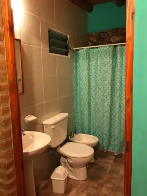 a bathroom with a toilet and a sink and a shower at Departamentos la Familia NONO in Nono