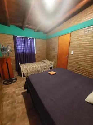 a room with two beds and a window in it at Departamentos la Familia NONO in Nono