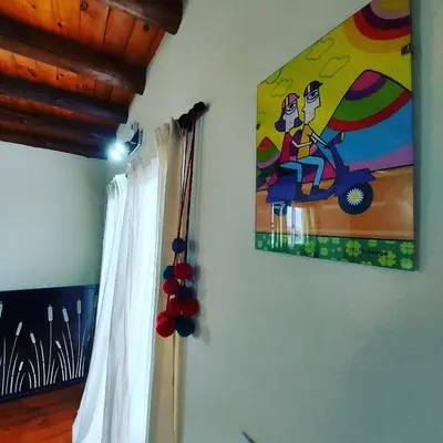 a painting of a woman on a motorcycle on a wall at Complejo SARA HOUSE in Santa Rosa de Calamuchita