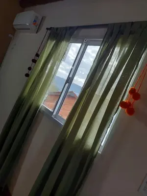 a window with green curtains in a room at Complejo SARA HOUSE in Santa Rosa de Calamuchita