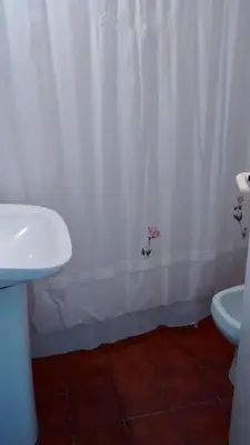 a bathroom with a white shower curtain and a sink at Cabañas San Gabriel Carlos Paz in Villa Carlos Paz