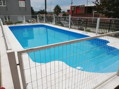 a swimming pool with a fence around it at Cabañas San Gabriel Carlos Paz in Villa Carlos Paz