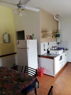 a kitchen with a white refrigerator and a table and chairs at Cabañas San Gabriel Carlos Paz in Villa Carlos Paz