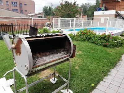 a toaster sitting in the grass next to a pool at Cabañas San Gabriel Carlos Paz in Villa Carlos Paz