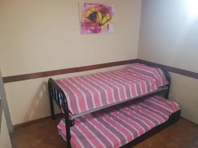 a bunk bed with a striped mattress in a room at Cabañas San Gabriel Carlos Paz in Villa Carlos Paz