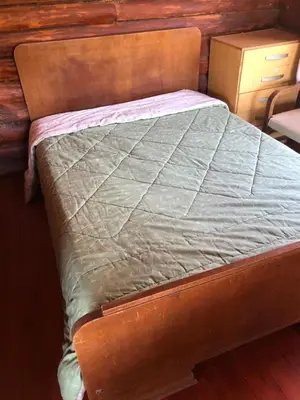 a bed in a bedroom with a wooden wall at Just Rest in Villa Serranita