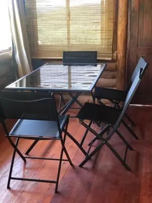 a glass table with two chairs and a laptop on it at Just Rest in Villa Serranita
