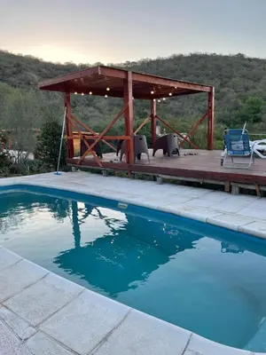 a swimming pool with a wooden deck and a pavilion at Just Rest in Villa Serranita