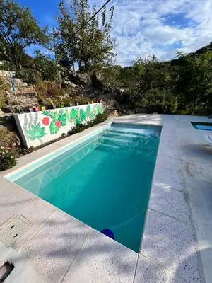 a swimming pool in a yard next to a sidewalk at Cabañas Namaskar in Villa Serranita