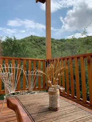 a vase sitting on a table on a deck at Cabañas Namaskar in Villa Serranita