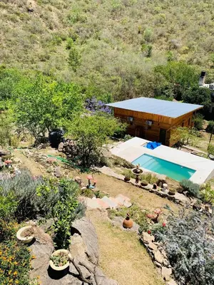 a backyard with a swimming pool and a house at Cabañas Namaskar in Villa Serranita