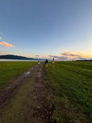 three people walking down a dirt road in a field at Cabañas Sueño Dorado in Potrero de Garay