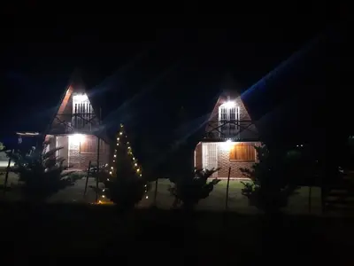a christmas tree in front of a house at night at Cabañas Sueño Dorado in Potrero de Garay
