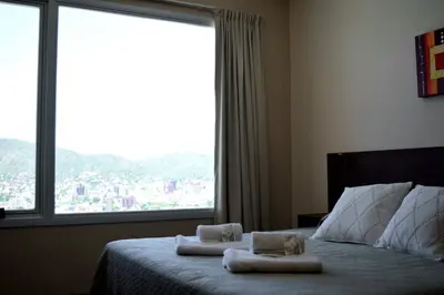 a bedroom with towels on a bed with a large window at Alamo Hotel in Villa Carlos Paz