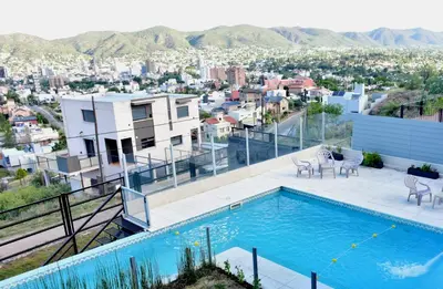 a swimming pool on the roof of a house with a city at Alamo Hotel in Villa Carlos Paz