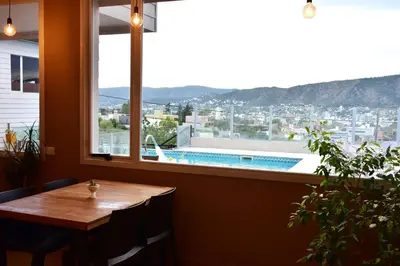 a table and a window with a view of a pool at Alamo Hotel in Villa Carlos Paz