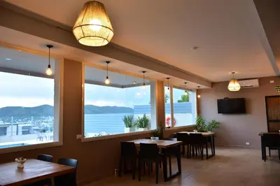 a restaurant with tables and chairs and large windows at Alamo Hotel in Villa Carlos Paz