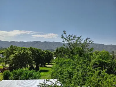 a view of a field with trees and mountains at Duplex Alto El Espinillo in Villa General Belgrano
