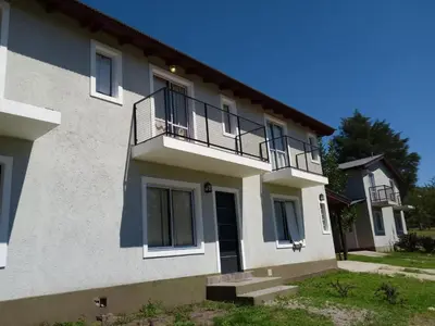 a white house with a balcony on the side of it at Duplex Alto El Espinillo in Villa General Belgrano