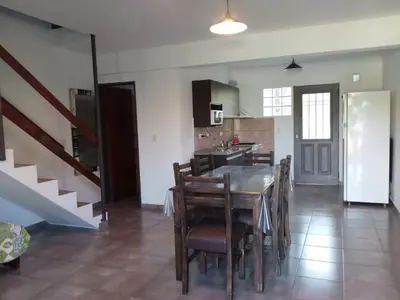 a kitchen and dining room with a table and chairs at Duplex Alto El Espinillo in Villa General Belgrano